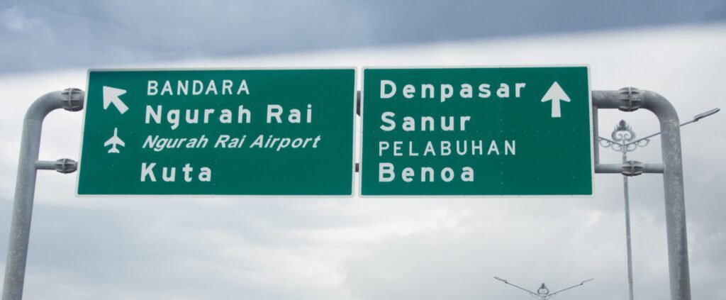 Tablice informacyjne na autortradzie na Bali zapisane pismem łacińskim